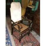 A 19th century carved oak Carolean armchair with cane seat and padded back.