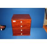 A small four drawer wooden chest,