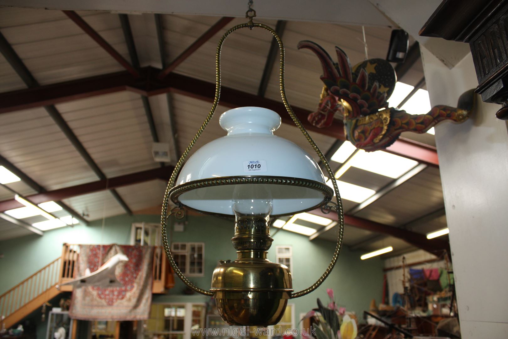 A large hanging Oil Lamp with funnel and white shade