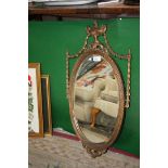 An oval wall Mirror in ornate gilt frame.