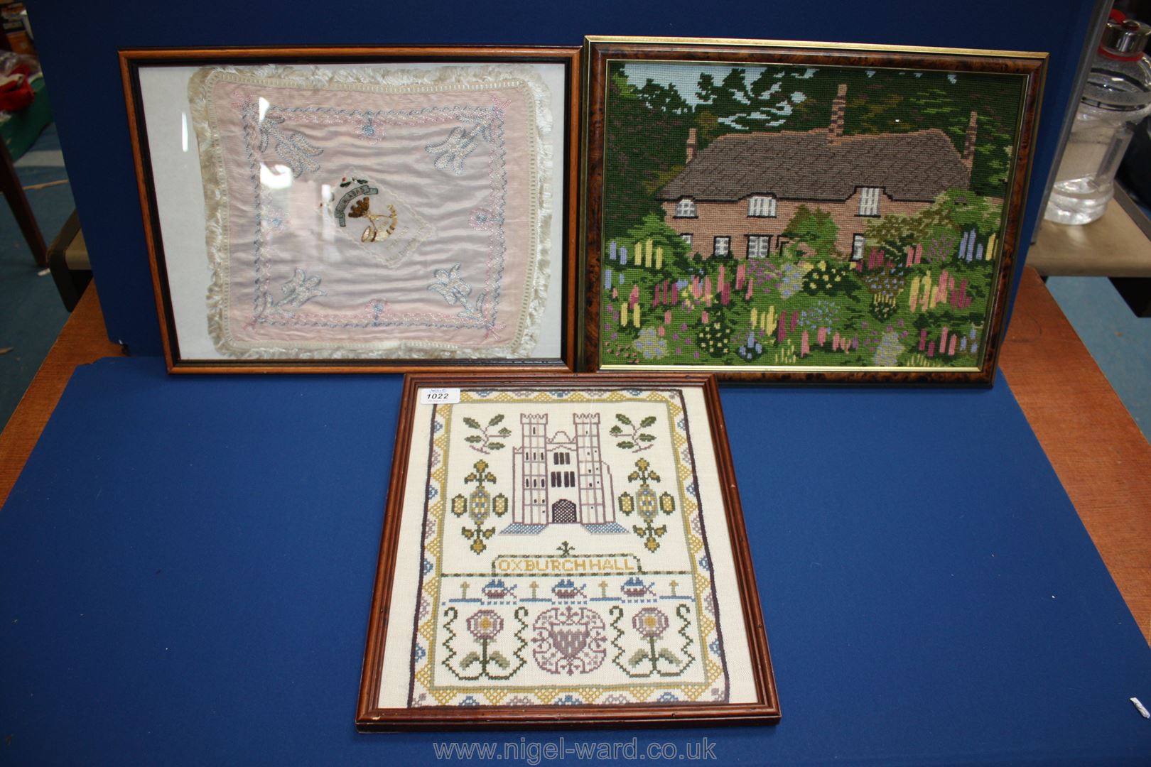 A cross stitch picture depicting a cottage,