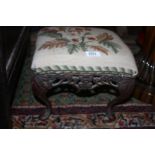 A small cast metal Footstool with needlepoint cover