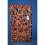 A Balinese hand carved Panel with detail of figures amongst shrubbery, 10 1/2'' x 18 1/4''.