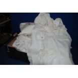 A box of linen and lace including tablecloths, napkins, apron, bonnet,