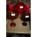 A purple brandy style Glass, amber coloured Brandy style Glass,
