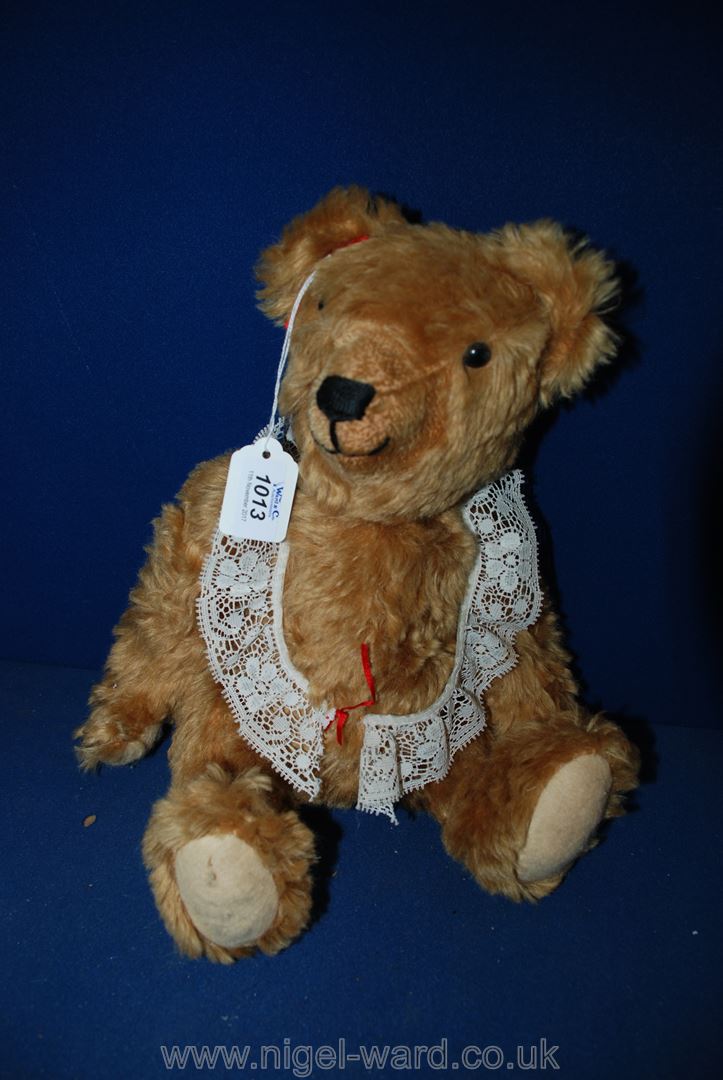 A straw filled, jointed Teddy Bear with long arms and angled paws, sewn nose,