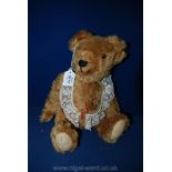 A straw filled, jointed Teddy Bear with long arms and angled paws, sewn nose,