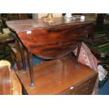 A Georgian Mahogany Drop leaf Table with oval top when open, on turned legs with pad feet.