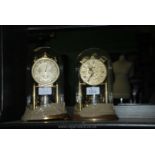 A glass domed Anniversary Clock with floral painted face and a similar clock with metal face.