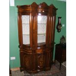 An Italian Cherry finished serpentine Vitrine style Cabinet having three upper bowed glass doors,