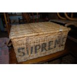 An old wicker Laundry Basket, 'Market Supreme' with leather straps,