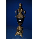 An ornate Brass and black china Table Lamp with pierced foliage decoration standing on a square