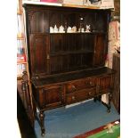 A reproduction Oak Dresser, the plate rack with five arches, two cupboards and central shelf,