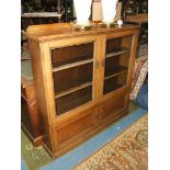 A 1940's Oak four door Bookcase, glazed pair of upper doors opening to reveal shelves,