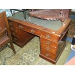 An Edwardian mahogany Kneehole Desk with inset green fabric top,