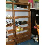 A large modern Pine open Bookcase with three narrow shelves over four lower wide shelves.