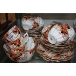 An imari coloured Teaset with scalloped edge including eleven cups, ten plates, twelve saucers,