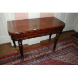 A Victorian Mahogany fold over Tea Table on turned fluted legs, 43" wide, 29 1/4" high.