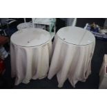 A pair of circular chipboard Bedside Tables with beige/red cloths and glass tops