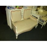 A small, white painted two seater Salon style Sofa.