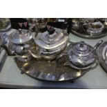 An oval silver plated Tray on four ball and claw feet and three plated Teapots