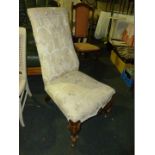 A modern upholstered Nursing Chair with heavily carved legs.