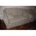 A large three seater beige upholstered Settee.