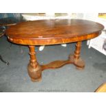 An Edwardian oval Mahogany Dining Table with two carved pillars on carved stretcher, 4'3" x 2'8".