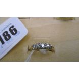 A FIVE STONE DIAMOND HALF ETERNITY RING SET INTO A YELLOW METAL SHANK,