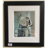 RINGO STARR SIGNED PHOTOGRAPH - A colour photograph of Ringo Starr playing the drums,