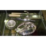 Shelf of assorted silver plated ware including crumb scoop, tongs, scent bottle etc.