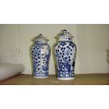 Harlequin pair of Chinese blue and white Kang zi vases with lids (with damages)