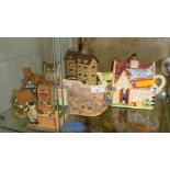 Shelf of pottery and resin cottage ornaments including David Winter & Lilliput Lane