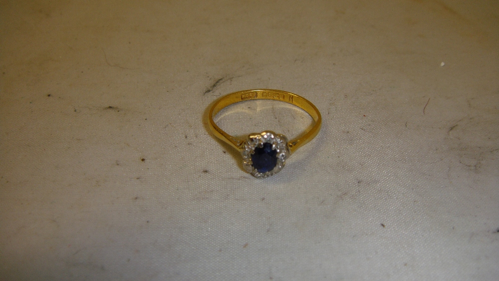 22 ct gold ring set with single sapphire surrounded by diamonds