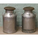 A pair of metal milk churns with lids.
