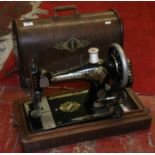 A cased manual Singer sewing machine.