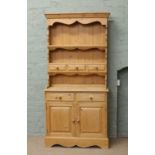 A pine kitchen dresser of slender proportions.