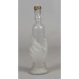 A glass bottle after James Hadley moulded being held by a female hand and with frosted decoration.