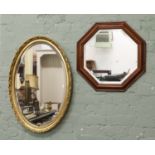 An oval gilt framed bevel edge wall mirror along with an hexagonal example.