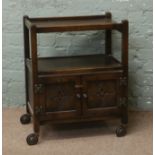 A mahogany Priory style tea trolley with cupboard base.