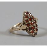 A 9 carat gold ring with boat shaped shank set with garnets. Size N.