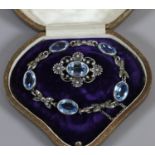 A silver blue topaz and marcasite bracelet and similar brooch in associated case.