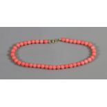 A pink coral bead bracelet with 14ct gold clasp.