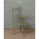 A decorative brass three tier what not stand each level pierced and ornamented with a butterfly,