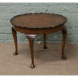 A burr walnut scallop edge coffee table raised on cabriole supports.