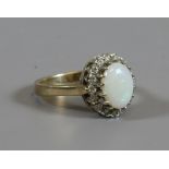 A 9ct gold opal dress ring set with a border of white paste, assayed Birmingham 1988, size K.