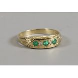 A 9ct gold gypsy ring set with three emeralds interspersed with diamonds, assayed Birmingham 1993,