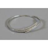 A silver bangle set with cubic zirconia.