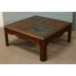 A carved hardwood coffee table with leaded glass top.