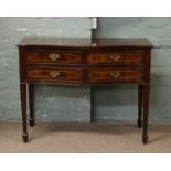 A mahogany serpentine side table with four fitted drawers raised on tapering supports.